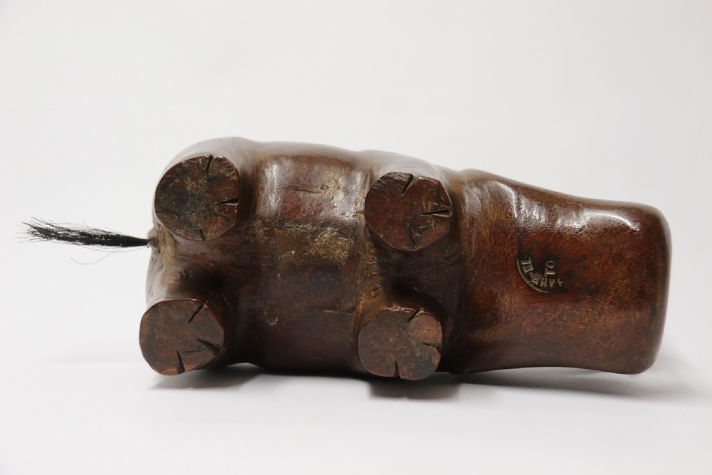 A dark brown carved hardwood hippopotamus sculpture with open mouth detailing inset bone teeth and carved body folds. View XVI