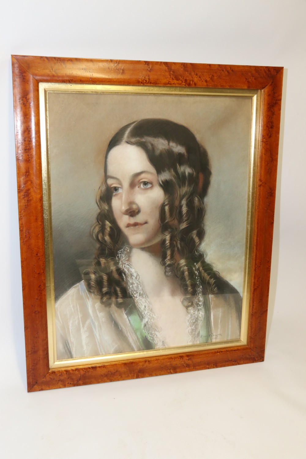 A mid-19th-century pastel portrait of a young woman with ringlets, presented in a rich burl wood frame with a gilt inner slip. View II