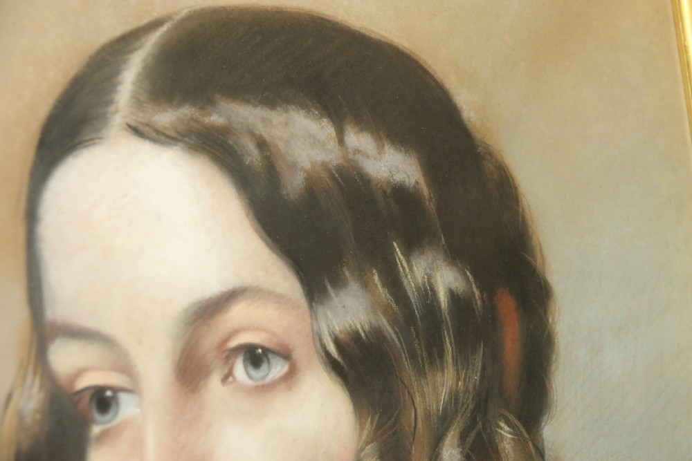 A mid-19th-century pastel portrait of a young woman with ringlets, presented in a rich burl wood frame with a gilt inner slip. View IV