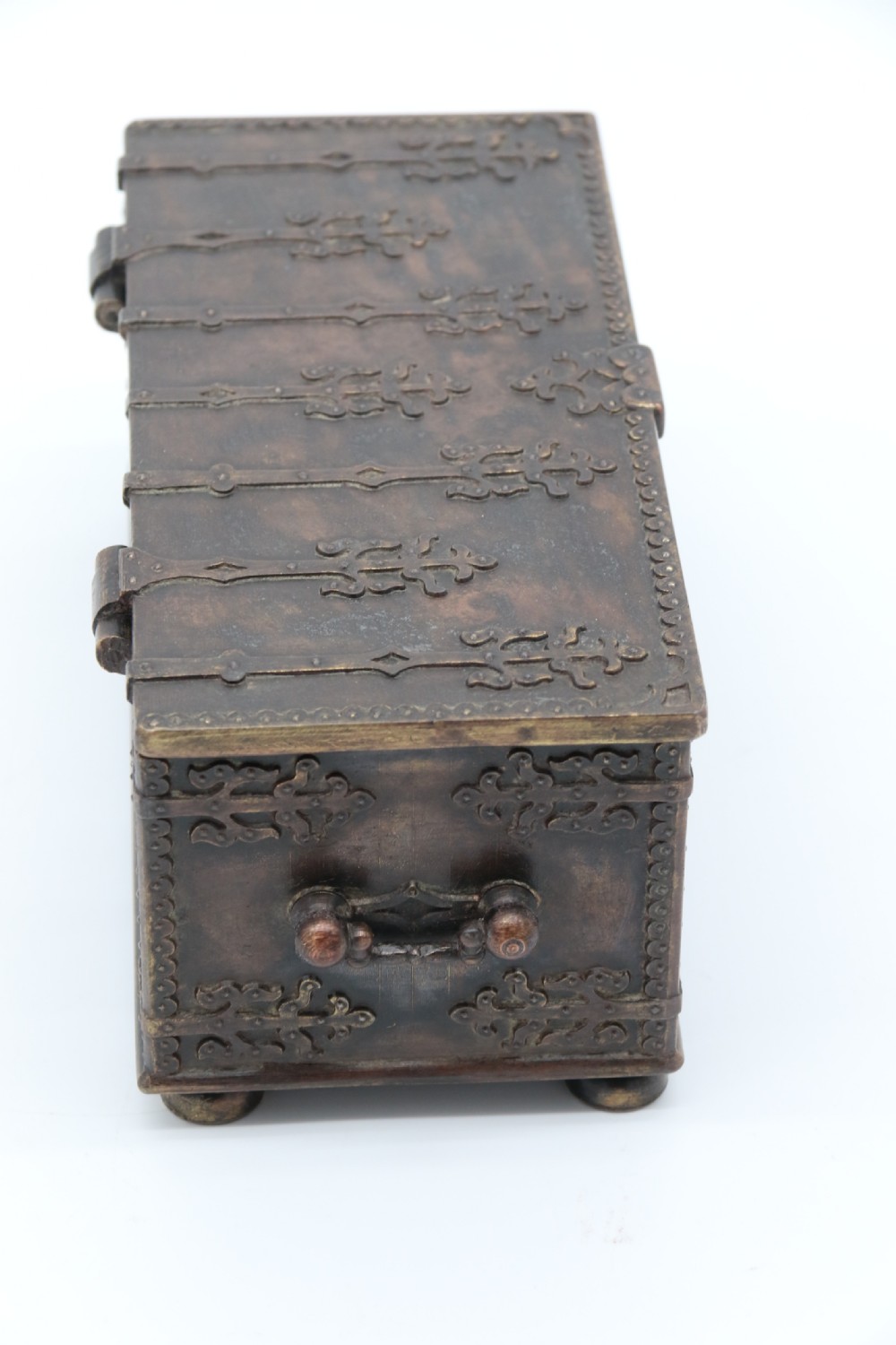A dark brown patinated cast metal trinket box fashioned in the form of a medieval coffer with relief figures and metal strapwork details. View III