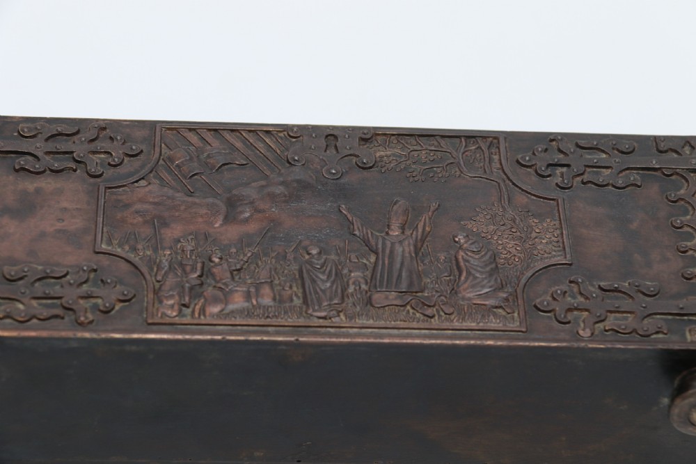 A dark brown patinated cast metal trinket box fashioned in the form of a medieval coffer with relief figures and metal strapwork details. View VIII