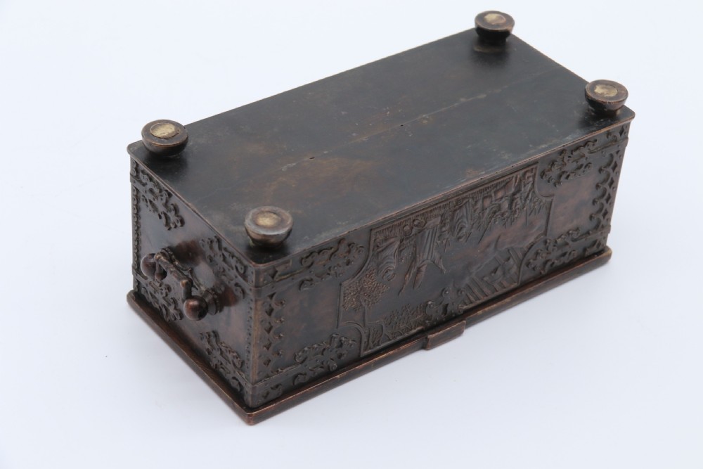 A dark brown patinated cast metal trinket box fashioned in the form of a medieval coffer with relief figures and metal strapwork details. View XI