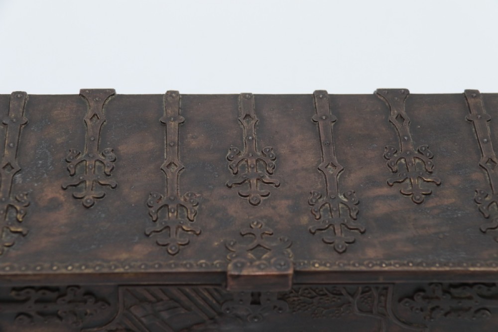 A dark brown patinated cast metal trinket box fashioned in the form of a medieval coffer with relief figures and metal strapwork details. View XII