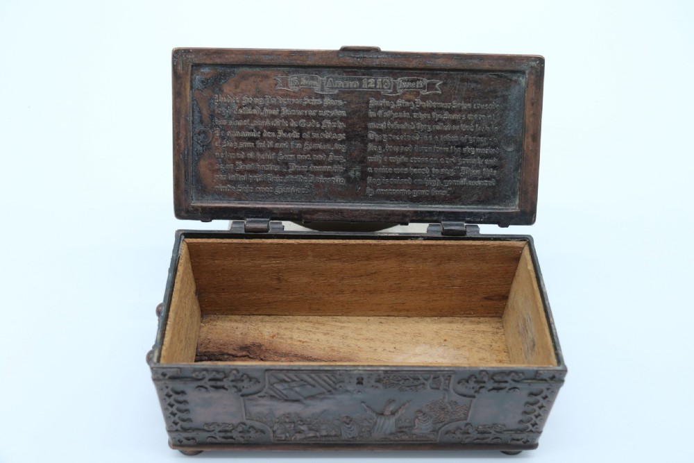 A dark brown patinated cast metal trinket box fashioned in the form of a medieval coffer with relief figures and metal strapwork details. View XIV