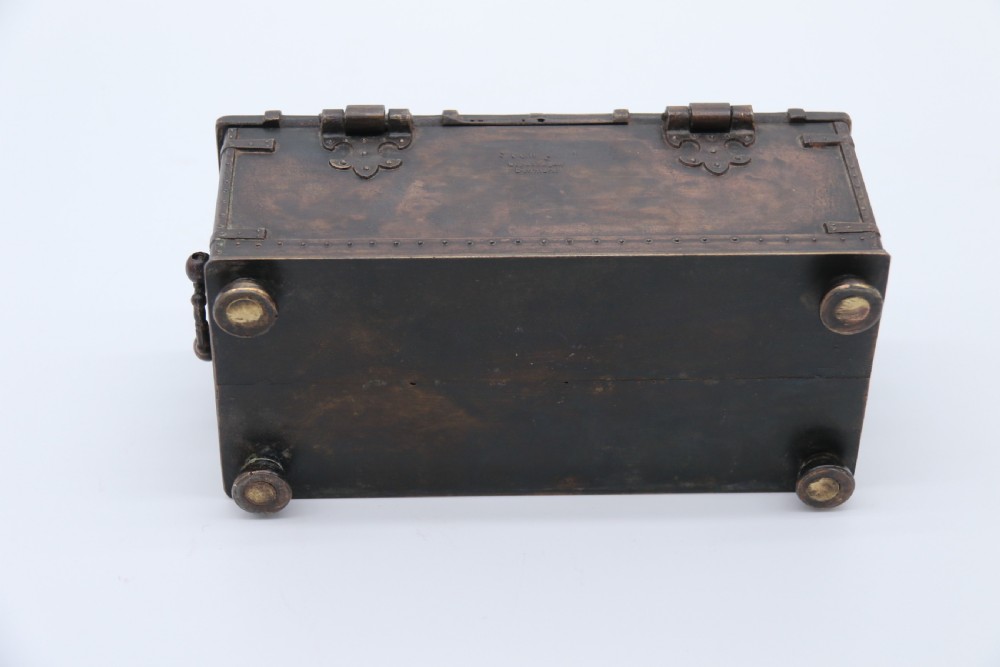 A dark brown patinated cast metal trinket box fashioned in the form of a medieval coffer with relief figures and metal strapwork details. View XVII
