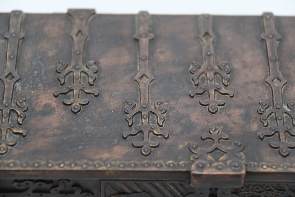 A dark brown patinated cast metal trinket box fashioned in the form of a medieval coffer with relief figures and metal strapwork details. View XVIII