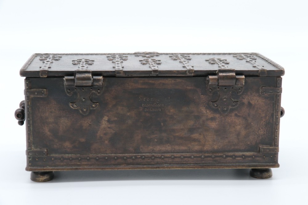 A dark brown patinated cast metal trinket box fashioned in the form of a medieval coffer with relief figures and metal strapwork details. View XIX