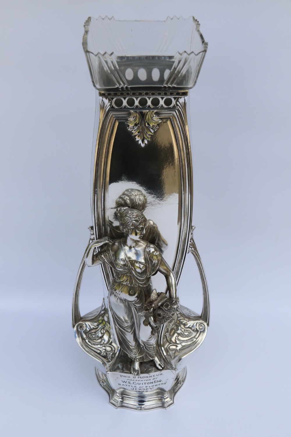 An Art Nouveau silver-plated WMF vase featuring a sculpted maiden figure in relief, sweeping organic handles, and a cut glass rim insert.