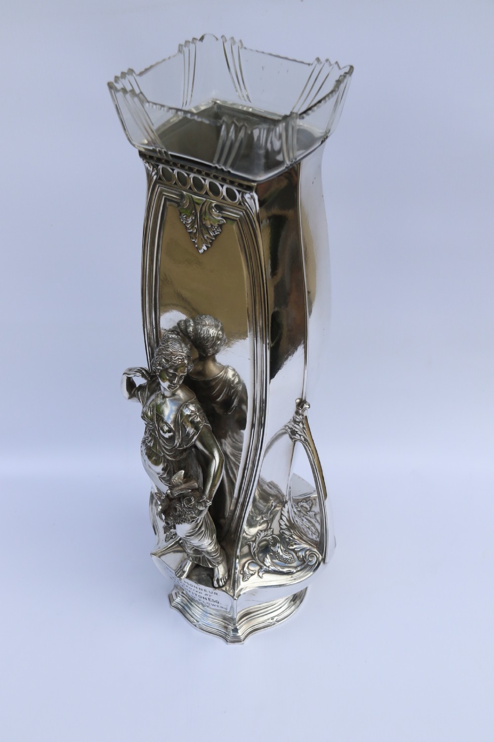 An Art Nouveau silver-plated WMF vase featuring a sculpted maiden figure in relief, sweeping organic handles, and a cut glass rim insert. View IX