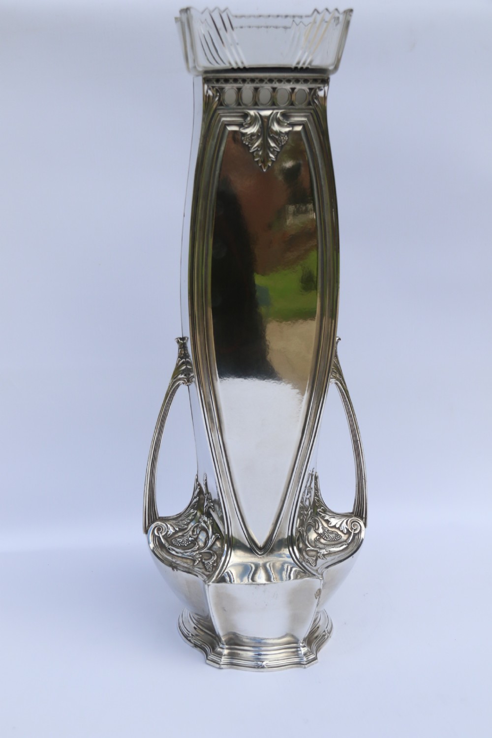 An Art Nouveau silver-plated WMF vase featuring a sculpted maiden figure in relief, sweeping organic handles, and a cut glass rim insert. View XII