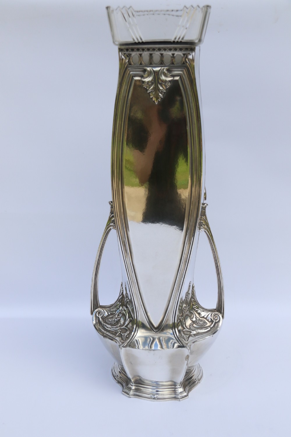 An Art Nouveau silver-plated WMF vase featuring a sculpted maiden figure in relief, sweeping organic handles, and a cut glass rim insert. View XIII