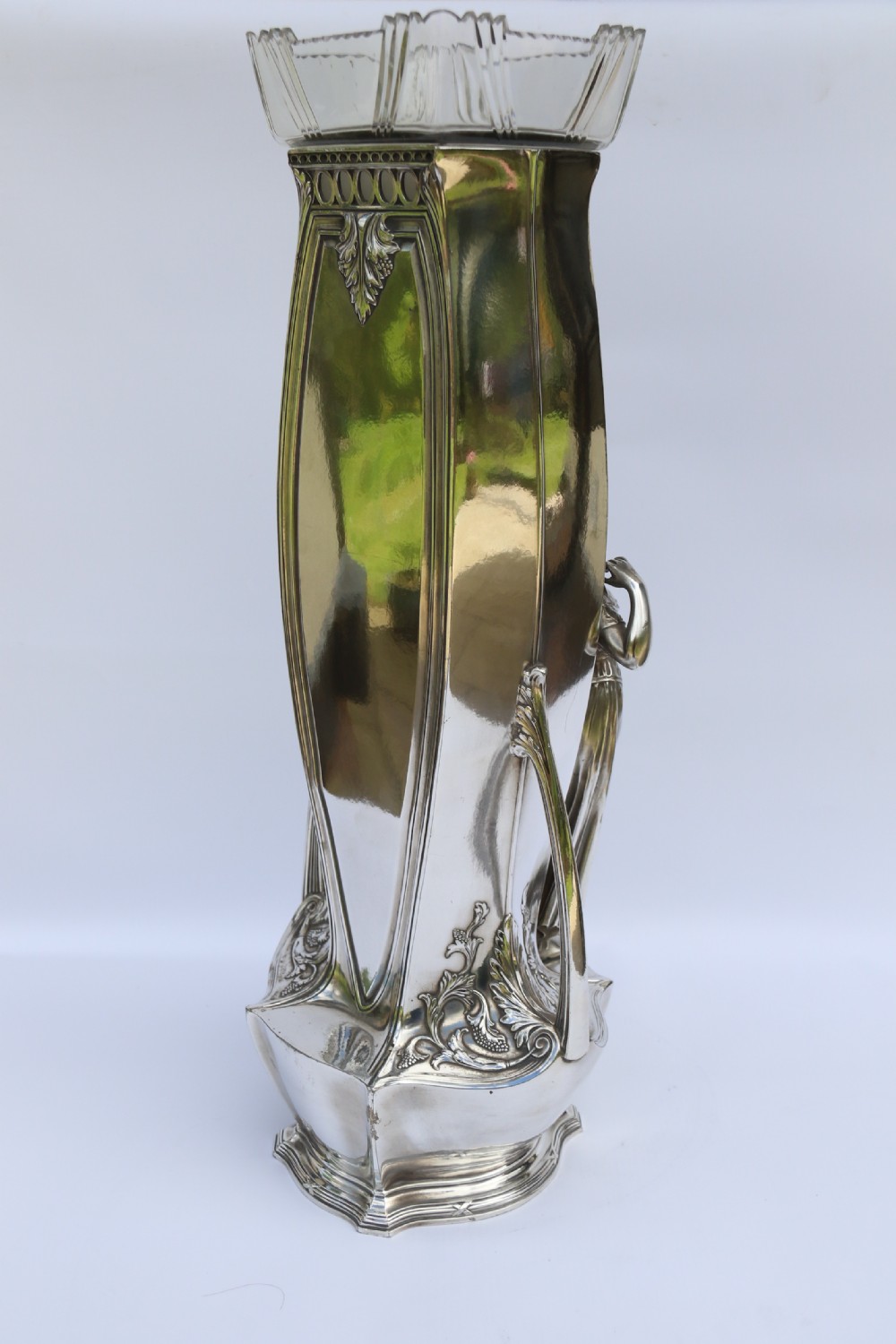 An Art Nouveau silver-plated WMF vase featuring a sculpted maiden figure in relief, sweeping organic handles, and a cut glass rim insert. View XV