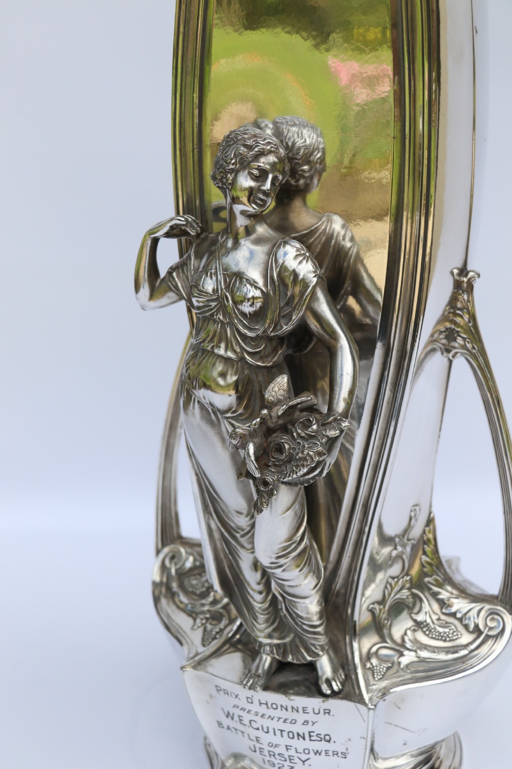 An Art Nouveau silver-plated WMF vase featuring a sculpted maiden figure in relief, sweeping organic handles, and a cut glass rim insert. View XIX