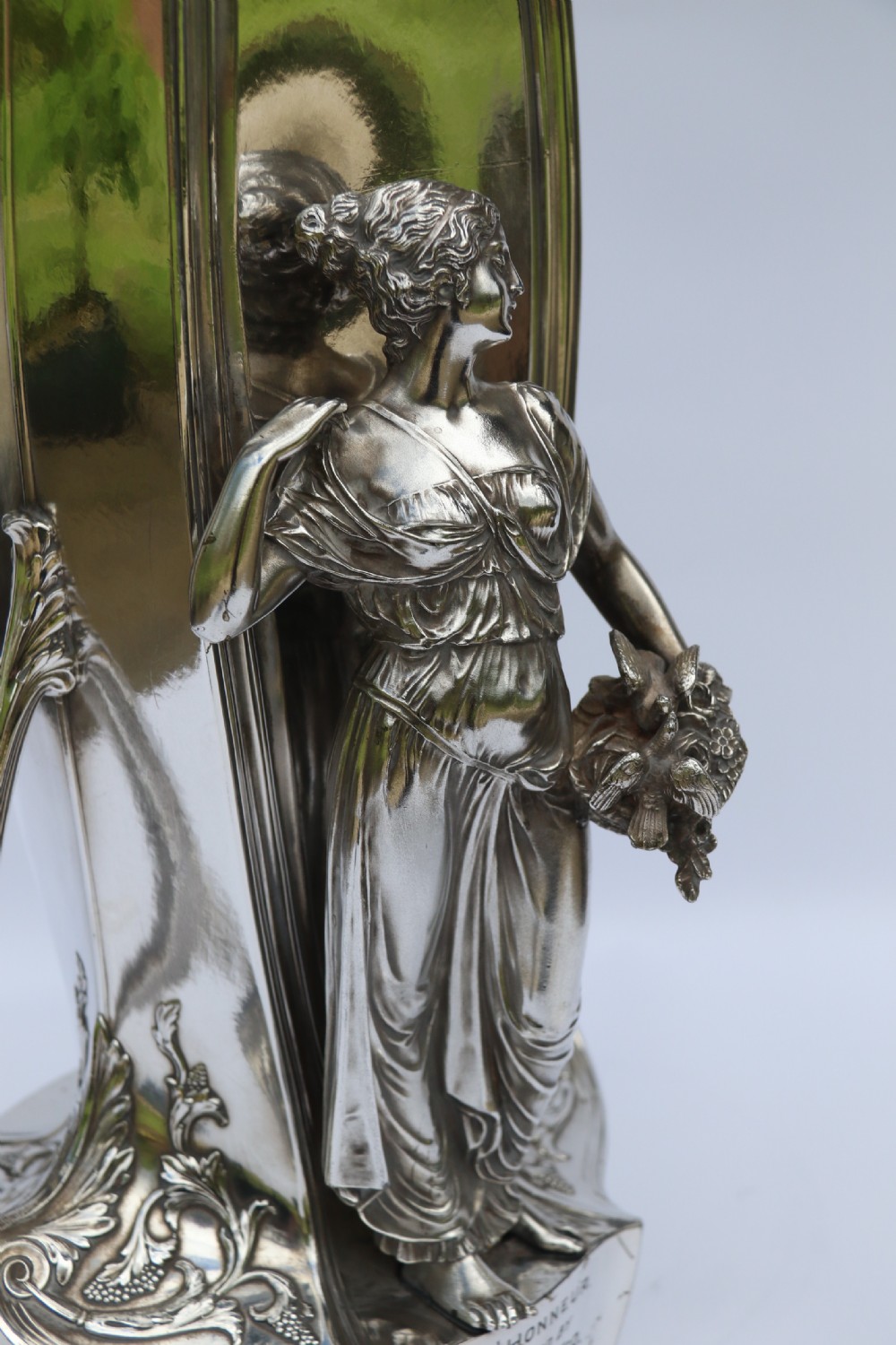 An Art Nouveau silver-plated WMF vase featuring a sculpted maiden figure in relief, sweeping organic handles, and a cut glass rim insert. View XXIV