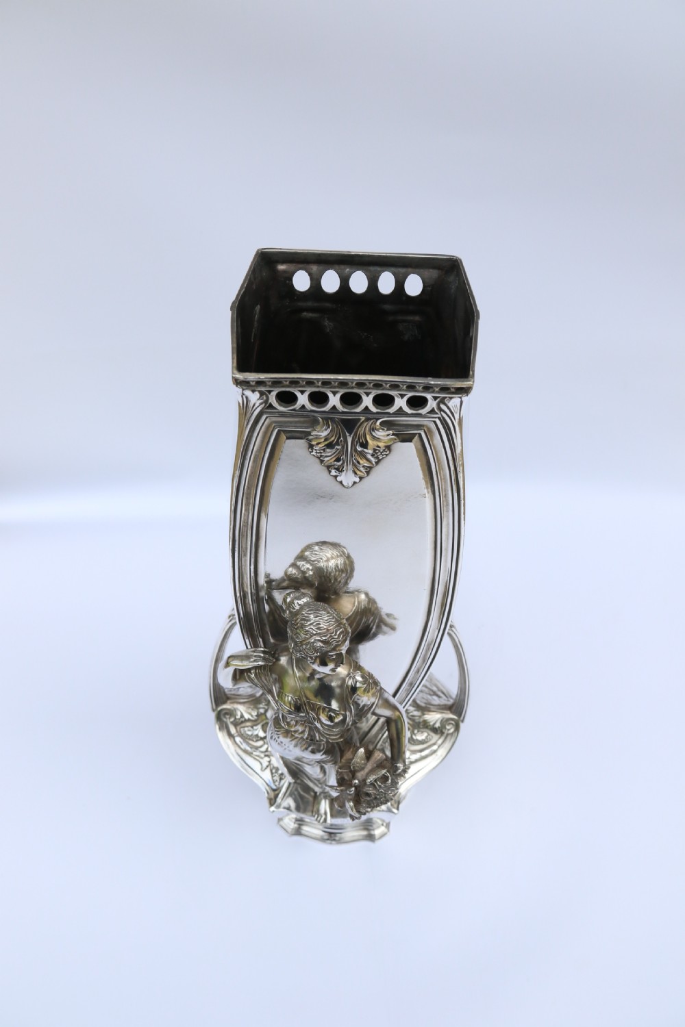 An Art Nouveau silver-plated WMF vase featuring a sculpted maiden figure in relief, sweeping organic handles, and a cut glass rim insert. View XXXI