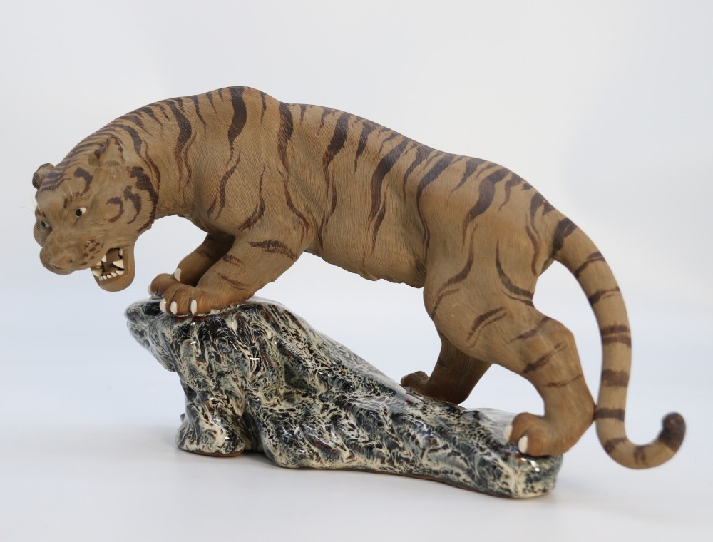 A late 19th-century Chinese Shiwan pottery tiger with incised fur texture and open jaws, standing upon a drip-glazed blue-grey rockwork base. View II