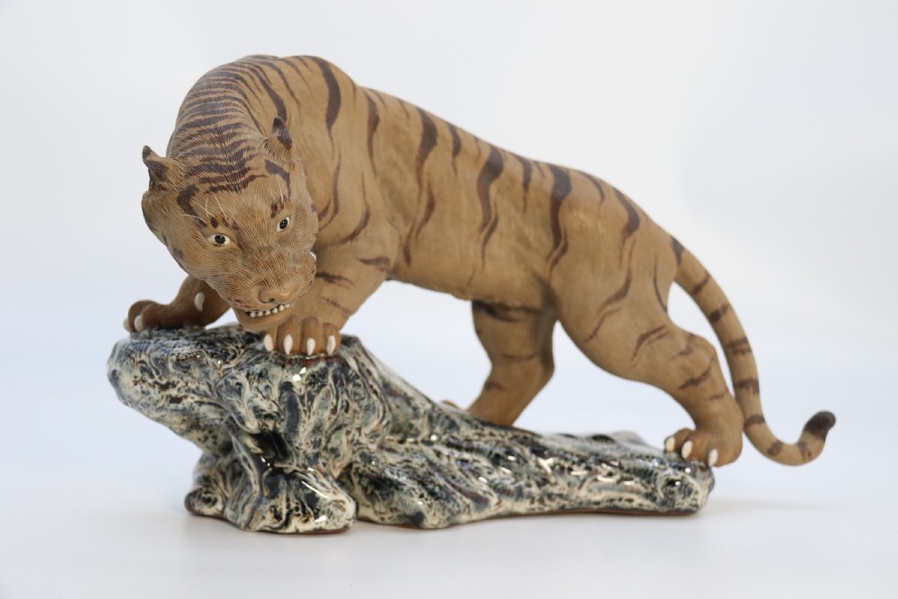 A late 19th-century Chinese Shiwan pottery tiger with incised fur texture and open jaws, standing upon a drip-glazed blue-grey rockwork base. View III