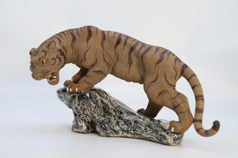 A late 19th-century Chinese Shiwan pottery tiger with incised fur texture and open jaws, standing upon a drip-glazed blue-grey rockwork base. View IV