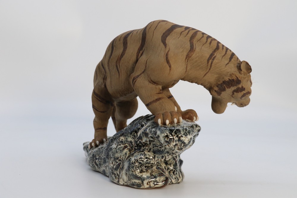 A late 19th-century Chinese Shiwan pottery tiger with incised fur texture and open jaws, standing upon a drip-glazed blue-grey rockwork base. View VII