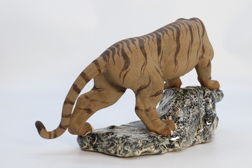 A late 19th-century Chinese Shiwan pottery tiger with incised fur texture and open jaws, standing upon a drip-glazed blue-grey rockwork base. View IX