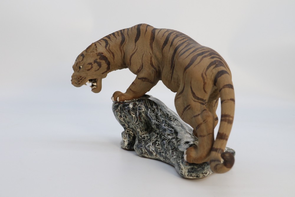 A late 19th-century Chinese Shiwan pottery tiger with incised fur texture and open jaws, standing upon a drip-glazed blue-grey rockwork base. View XII