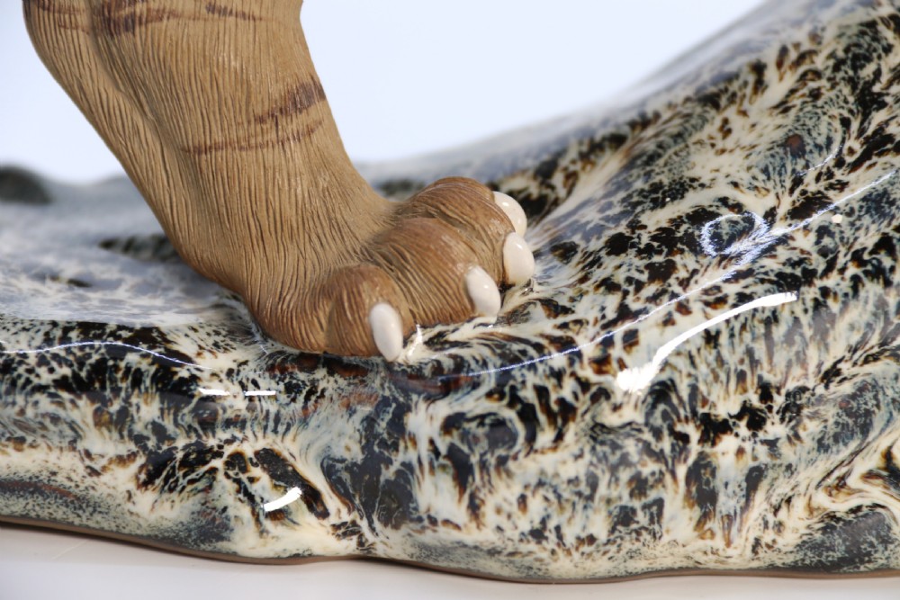 A late 19th-century Chinese Shiwan pottery tiger with incised fur texture and open jaws, standing upon a drip-glazed blue-grey rockwork base. View XIII