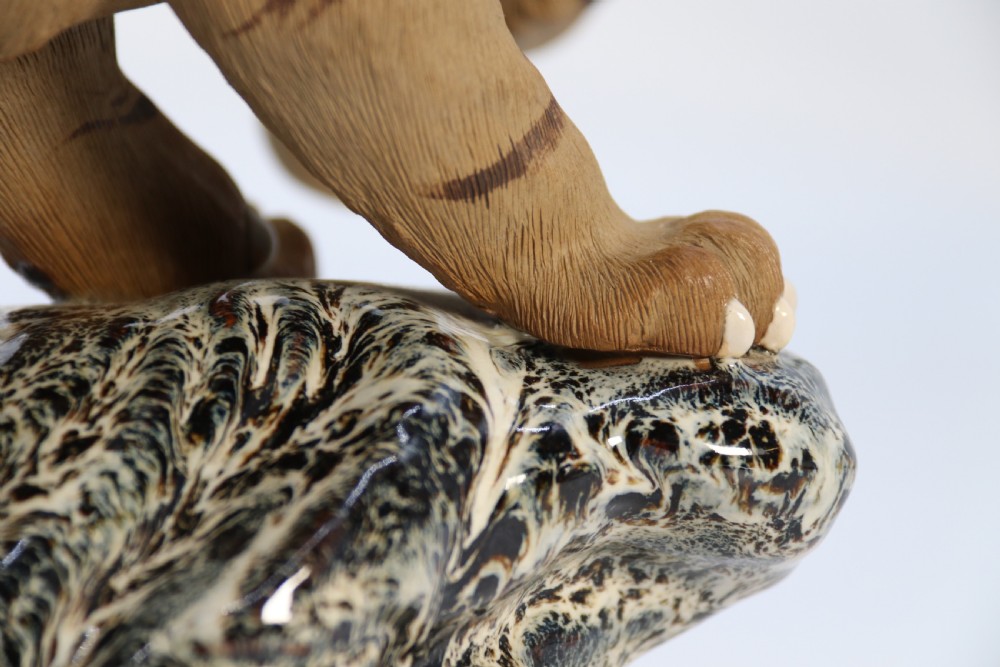 A late 19th-century Chinese Shiwan pottery tiger with incised fur texture and open jaws, standing upon a drip-glazed blue-grey rockwork base. View XIV
