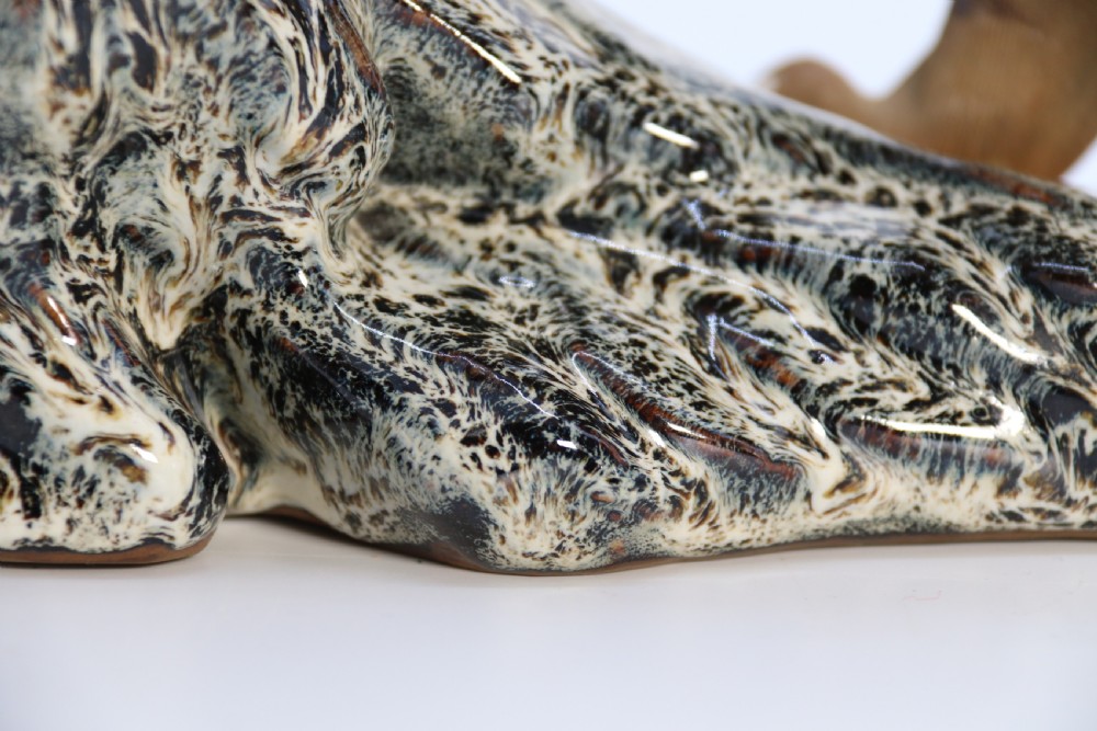 A late 19th-century Chinese Shiwan pottery tiger with incised fur texture and open jaws, standing upon a drip-glazed blue-grey rockwork base. View XV