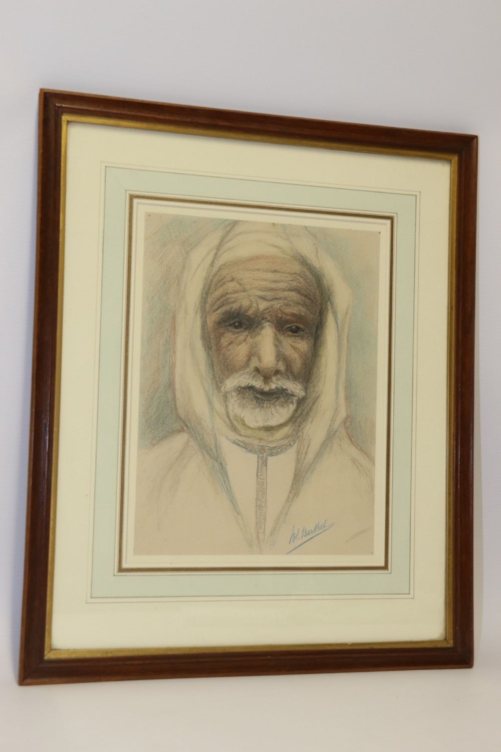 A framed late 19th-century portrait drawing on cream paper depicting an elderly Arabian man wearing a white hooded tunic. View II