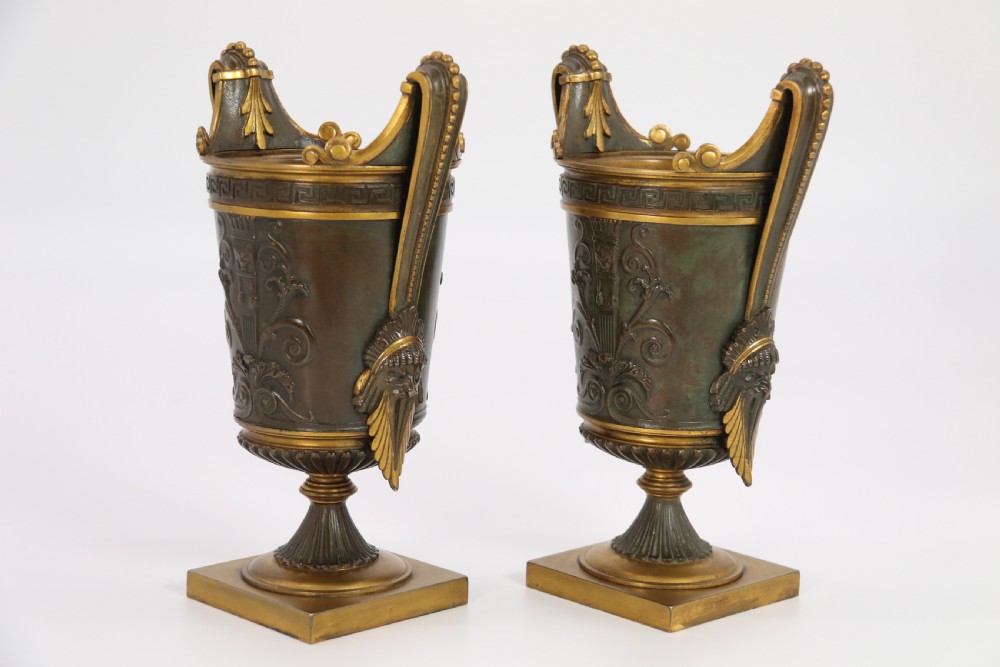 A pair of French Empire patinated and gilt bronze urns with Greek key friezes, scroll handles, and square bases. View III