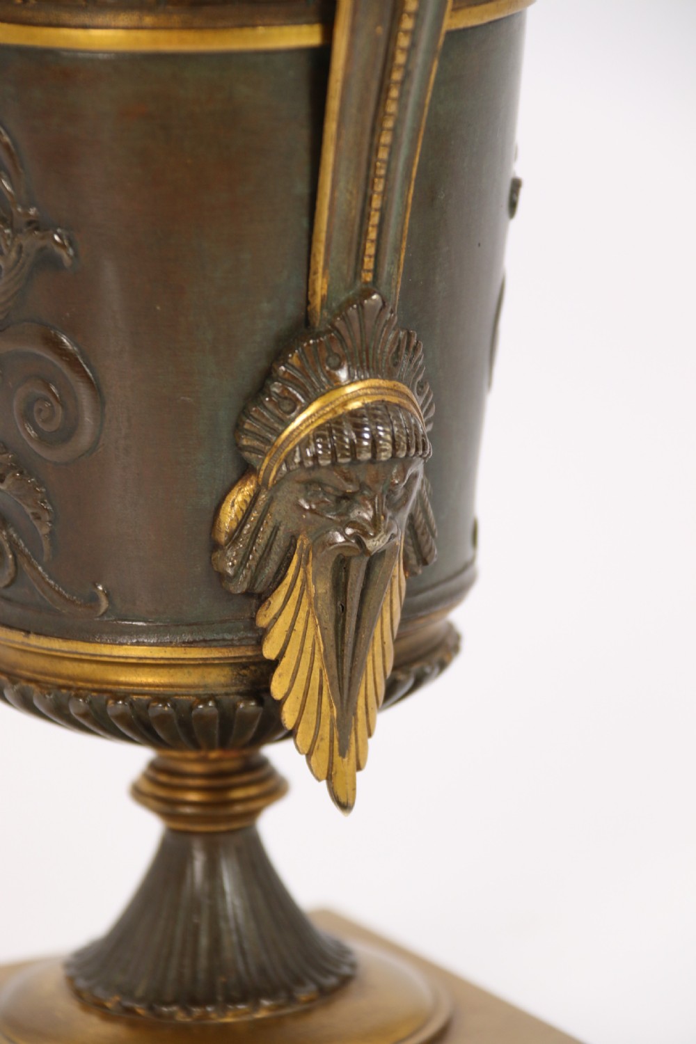 A pair of French Empire patinated and gilt bronze urns with Greek key friezes, scroll handles, and square bases. View XI