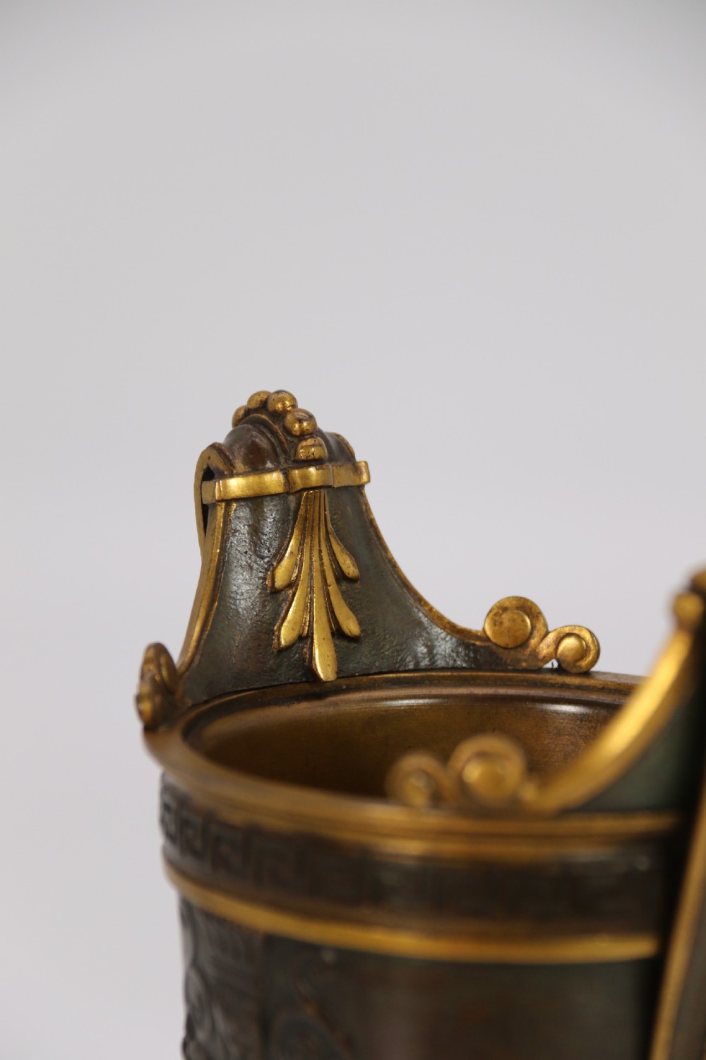 A pair of French Empire patinated and gilt bronze urns with Greek key friezes, scroll handles, and square bases. View XII