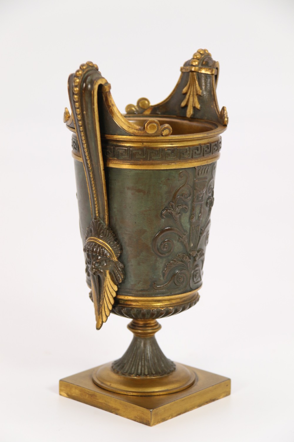 A pair of French Empire patinated and gilt bronze urns with Greek key friezes, scroll handles, and square bases. View XVI
