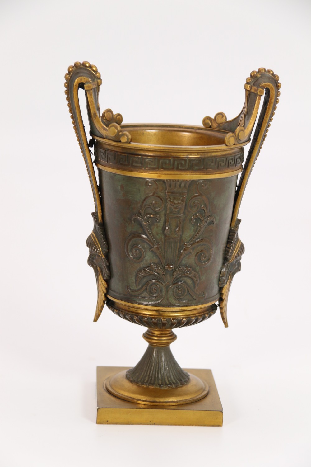 A pair of French Empire patinated and gilt bronze urns with Greek key friezes, scroll handles, and square bases. View XVIII