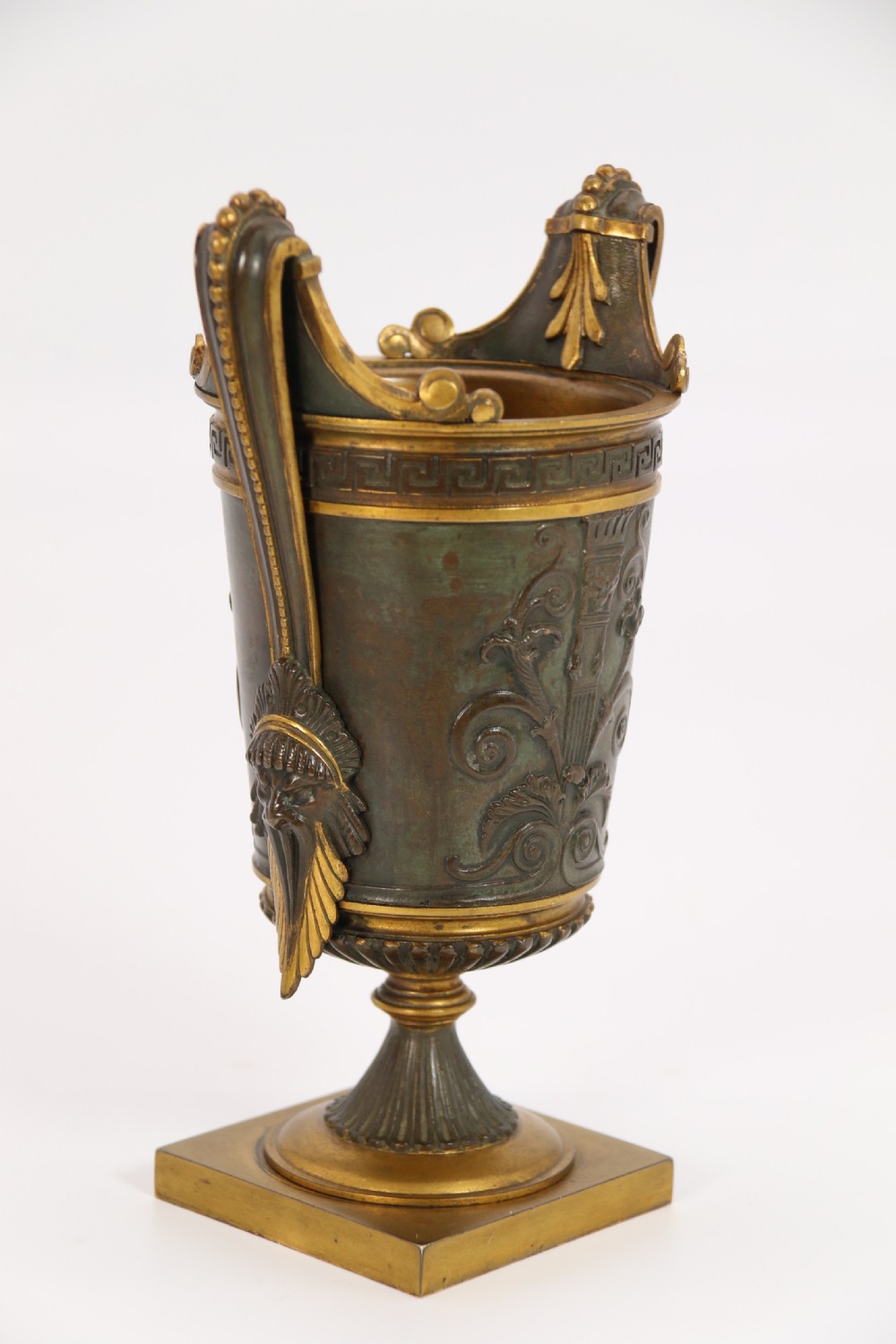 A pair of French Empire patinated and gilt bronze urns with Greek key friezes, scroll handles, and square bases. View XIX