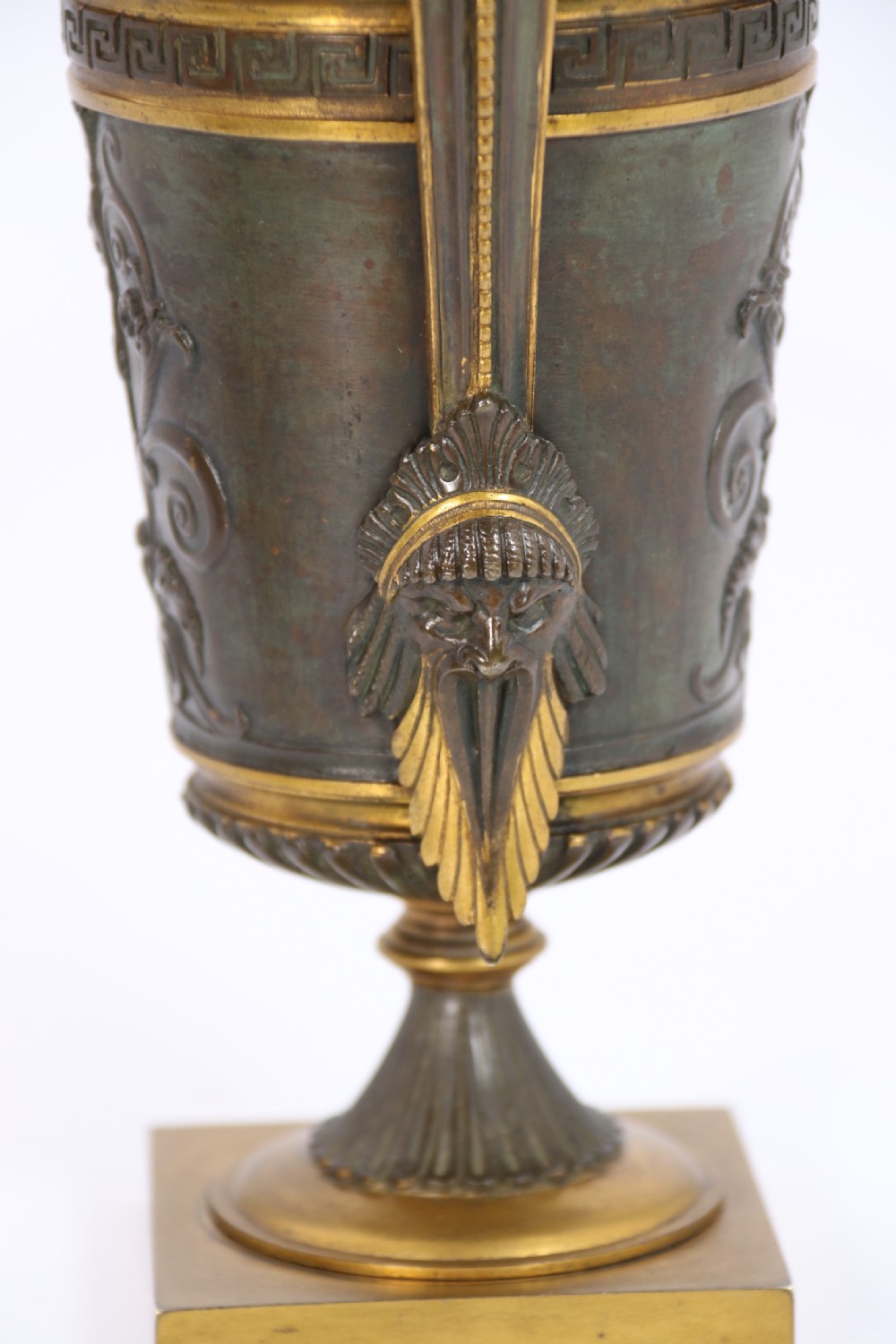 A pair of French Empire patinated and gilt bronze urns with Greek key friezes, scroll handles, and square bases. View XX