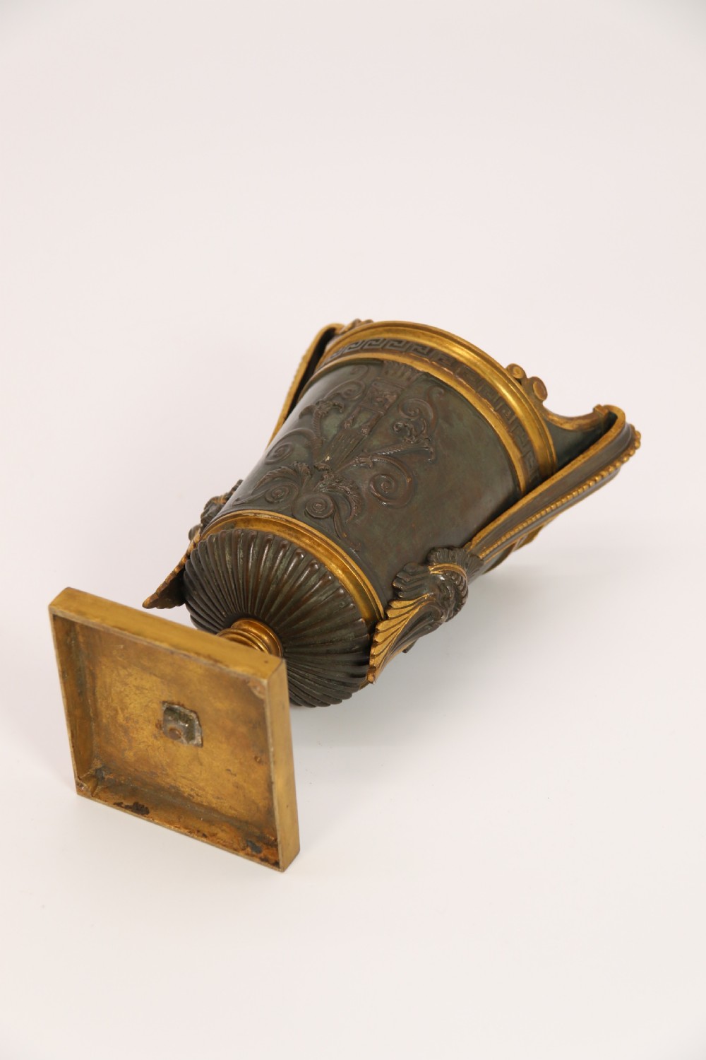 A pair of French Empire patinated and gilt bronze urns with Greek key friezes, scroll handles, and square bases. View XXIII