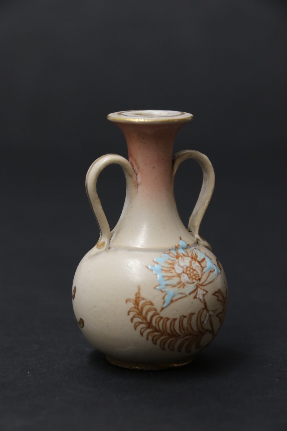 A set of three antique miniature cream ceramic vases featuring hand-painted floral motifs in blue, green, and brown with gilded highlights. View XV