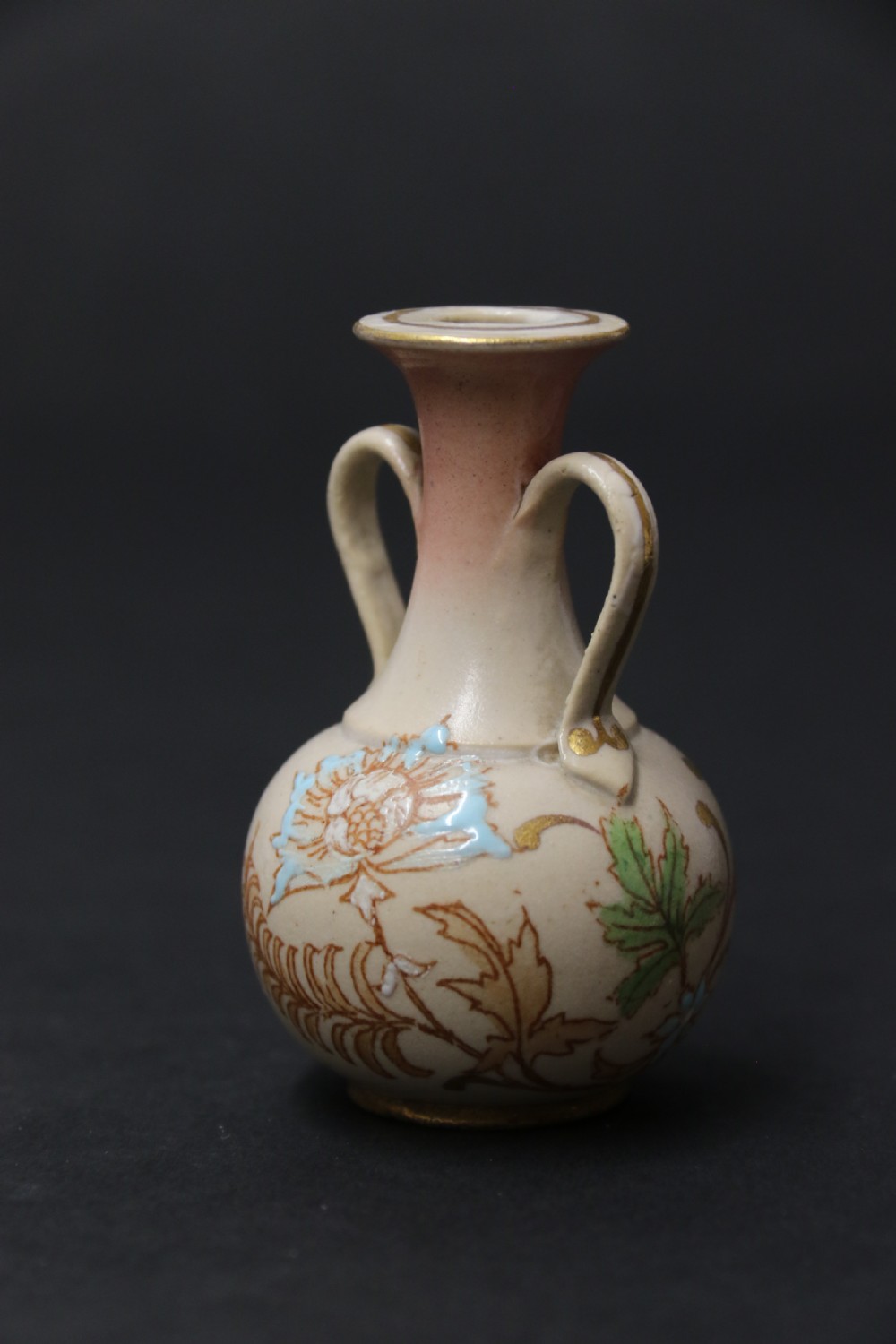 A set of three antique miniature cream ceramic vases featuring hand-painted floral motifs in blue, green, and brown with gilded highlights. View XVI