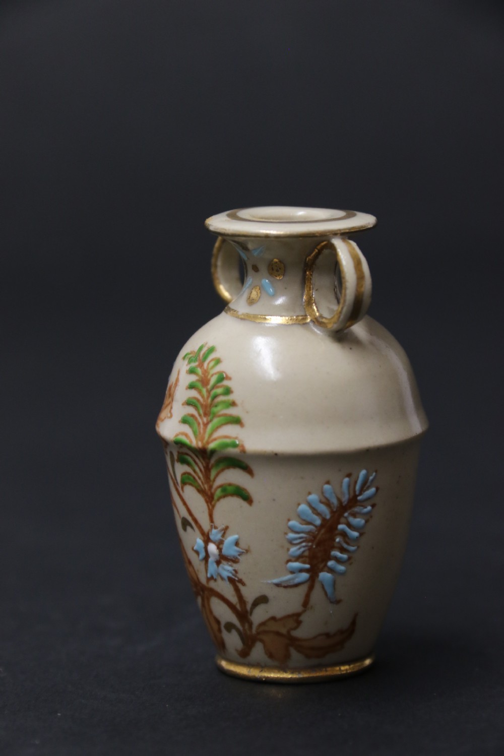 A set of three antique miniature cream ceramic vases featuring hand-painted floral motifs in blue, green, and brown with gilded highlights. View XIX