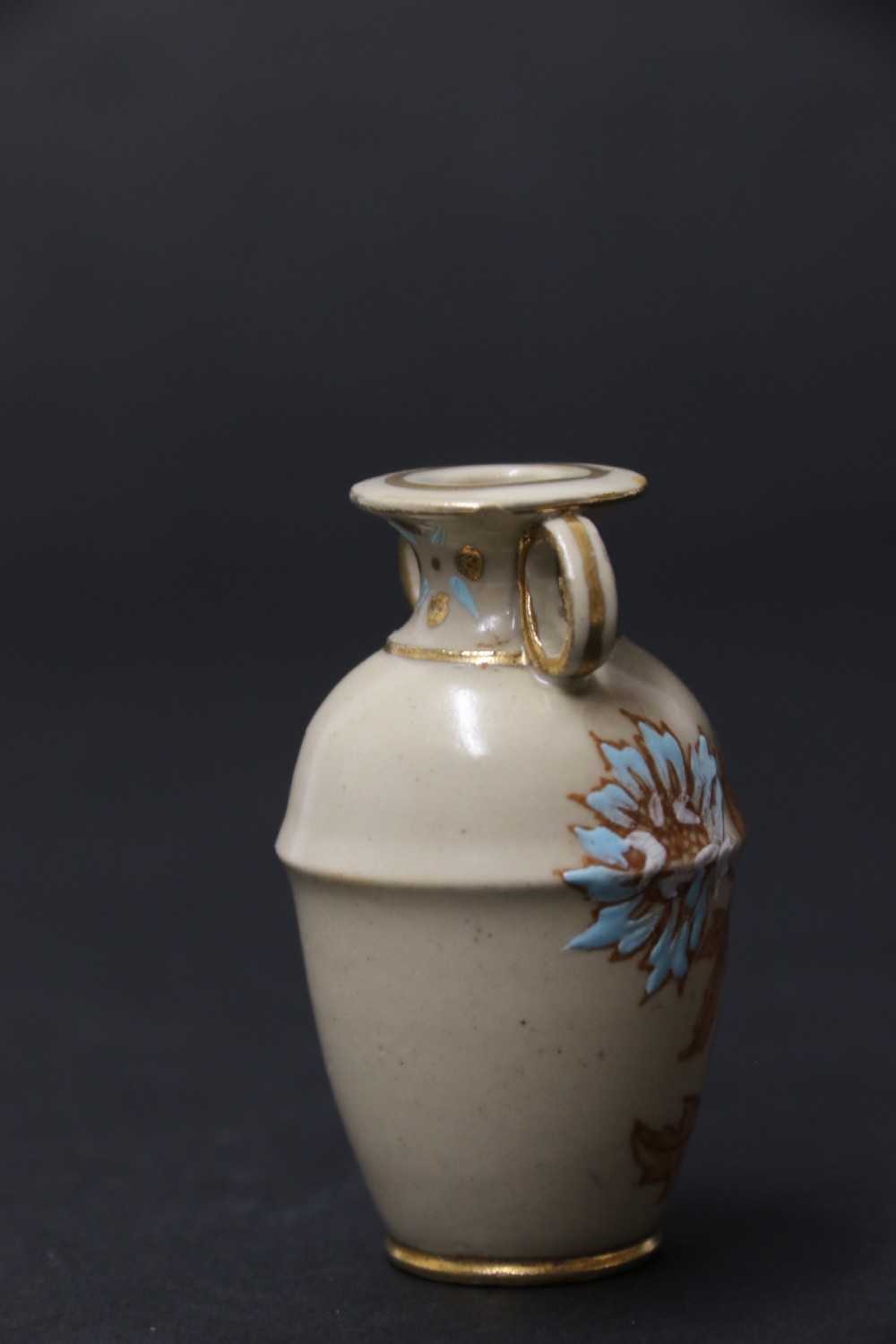 A set of three antique miniature cream ceramic vases featuring hand-painted floral motifs in blue, green, and brown with gilded highlights. View XXII