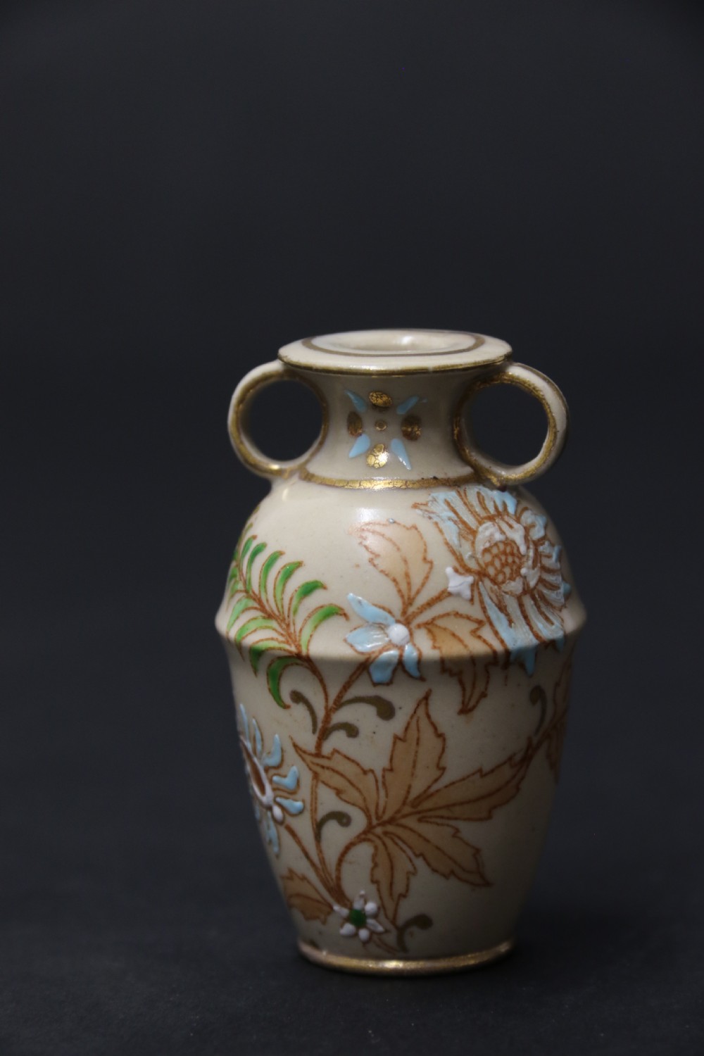 A set of three antique miniature cream ceramic vases featuring hand-painted floral motifs in blue, green, and brown with gilded highlights. View XXVI
