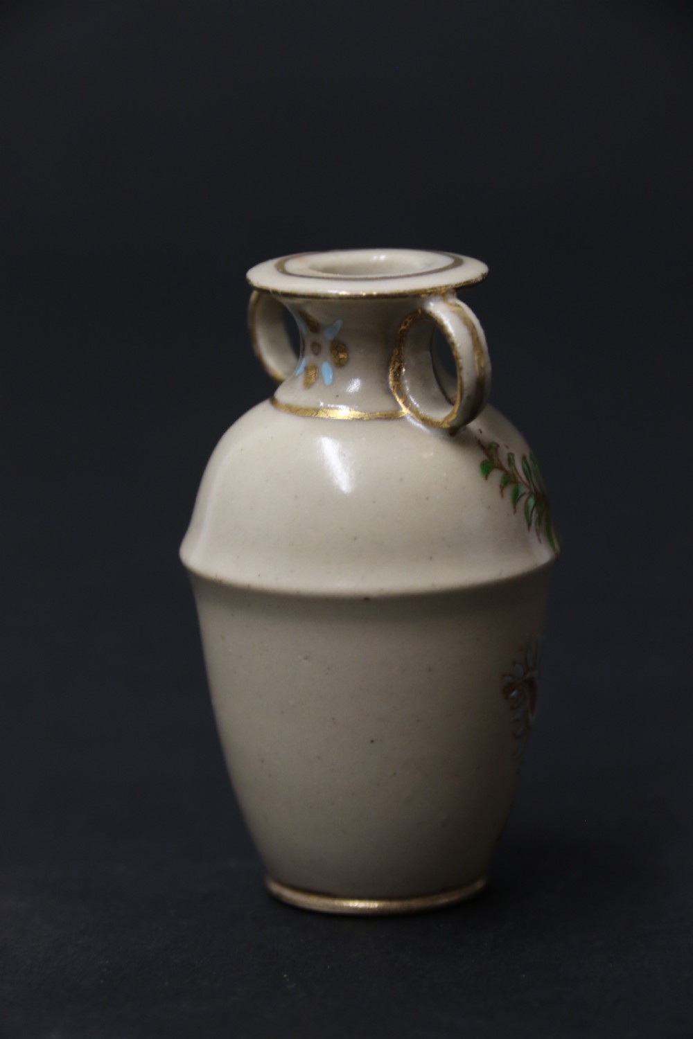 A set of three antique miniature cream ceramic vases featuring hand-painted floral motifs in blue, green, and brown with gilded highlights. View XXVIII