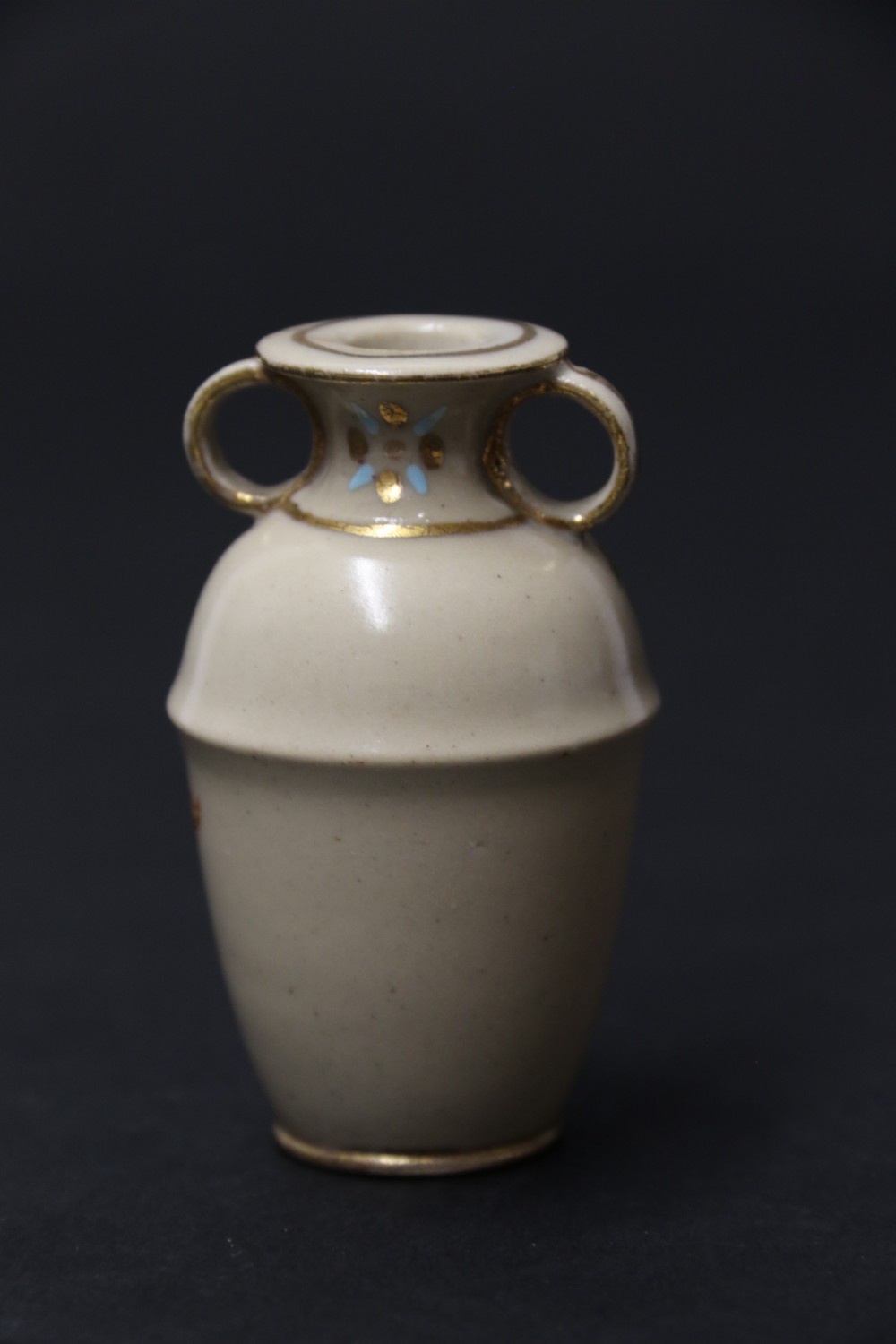 A set of three antique miniature cream ceramic vases featuring hand-painted floral motifs in blue, green, and brown with gilded highlights. View XXIX