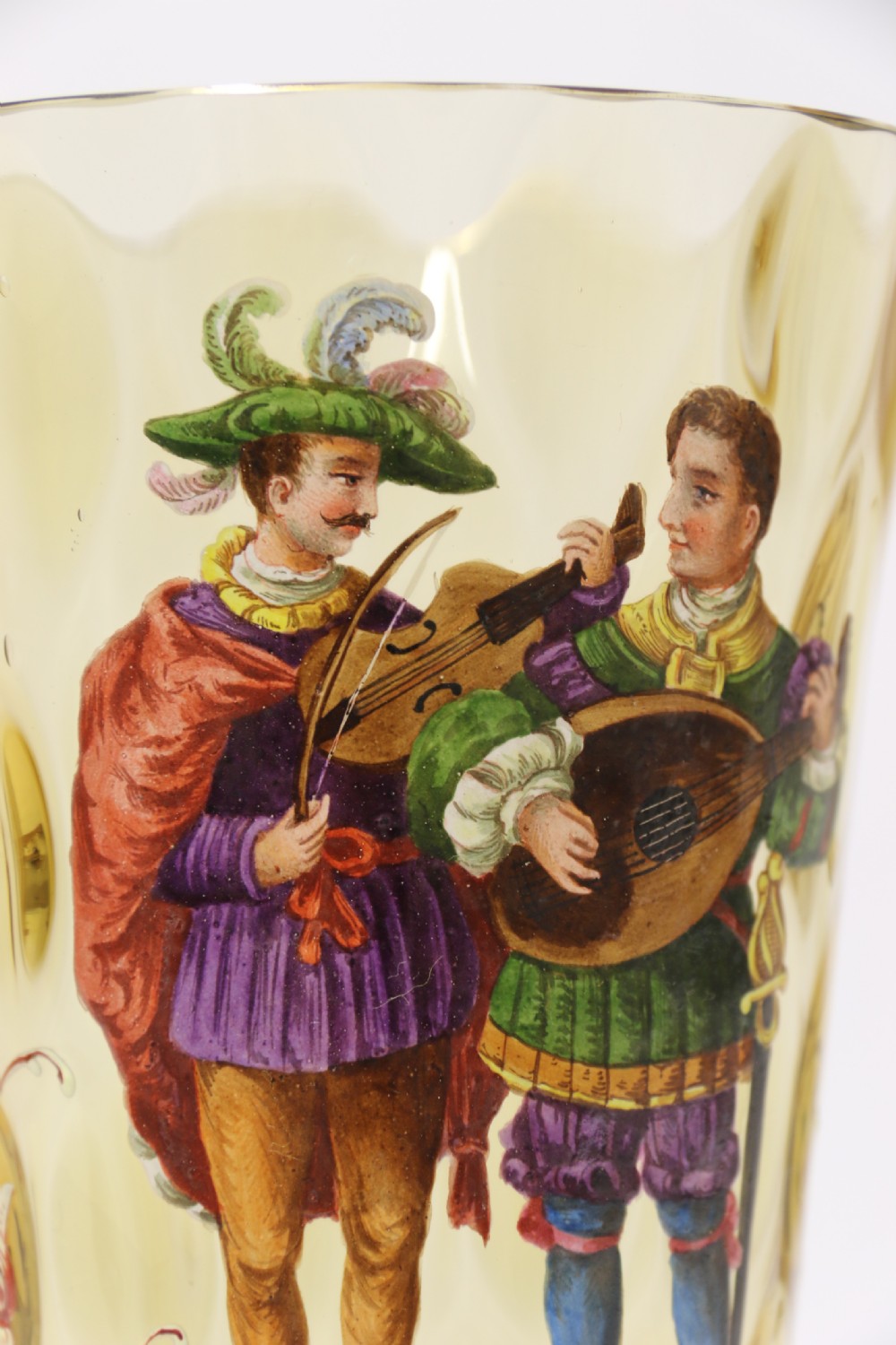 A pair of tall amber glass goblets featuring hand-painted enamelled figures of Renaissance musicians with scalloped rims and decorative knopped stems. View XIV