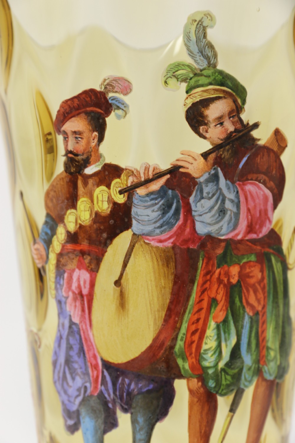 A pair of tall amber glass goblets featuring hand-painted enamelled figures of Renaissance musicians with scalloped rims and decorative knopped stems. View XVIII