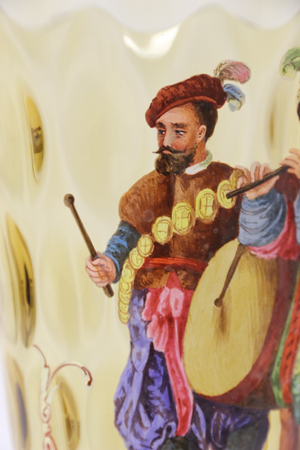 A pair of tall amber glass goblets featuring hand-painted enamelled figures of Renaissance musicians with scalloped rims and decorative knopped stems. View XX
