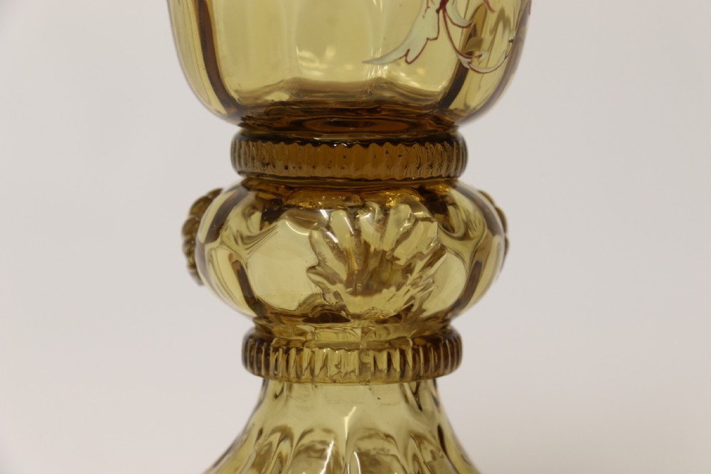 A pair of tall amber glass goblets featuring hand-painted enamelled figures of Renaissance musicians with scalloped rims and decorative knopped stems. View XXII