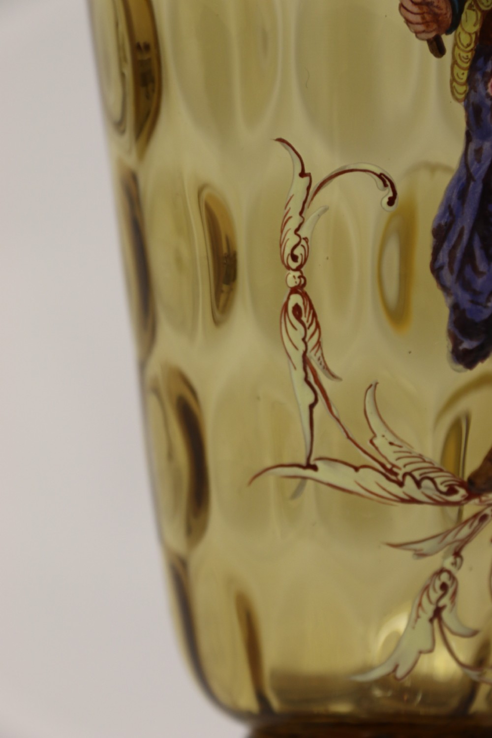 A pair of tall amber glass goblets featuring hand-painted enamelled figures of Renaissance musicians with scalloped rims and decorative knopped stems. View XXVII