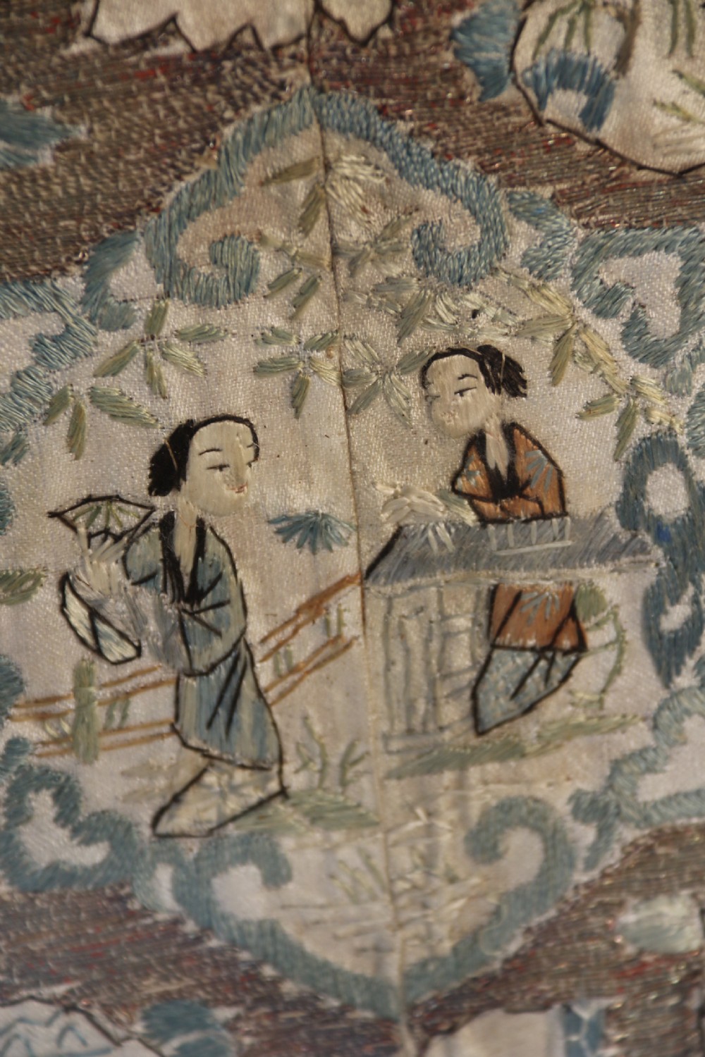 A circular carved dark hardwood tray containing an inset 19th-century Chinese silk embroidery with figural and botanical motifs. View XVII